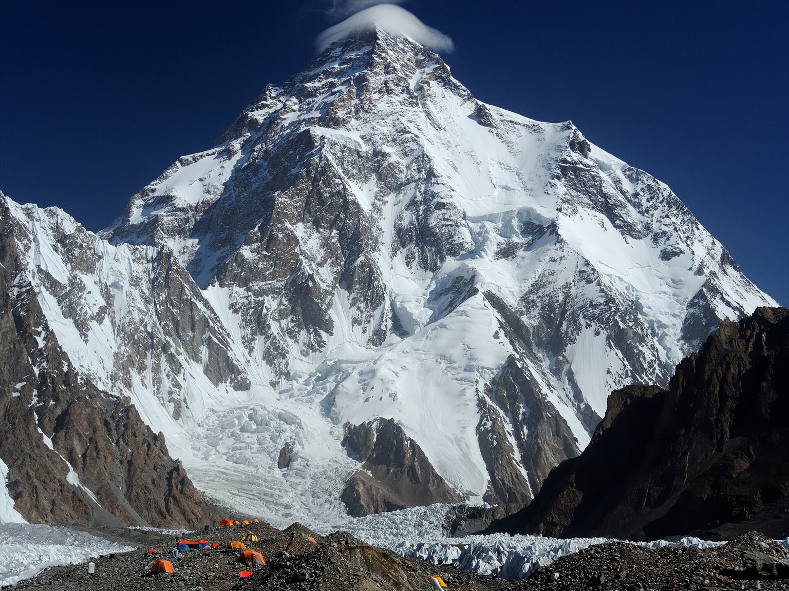 Snow-covered K2 above a glacier and expedition tents